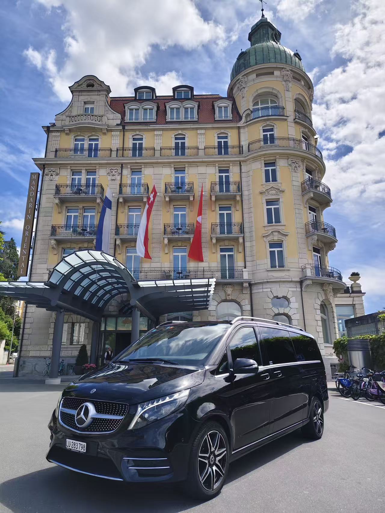 Black Mercedes-Benz V-Class 8-seater at a Swiss hotel entrance